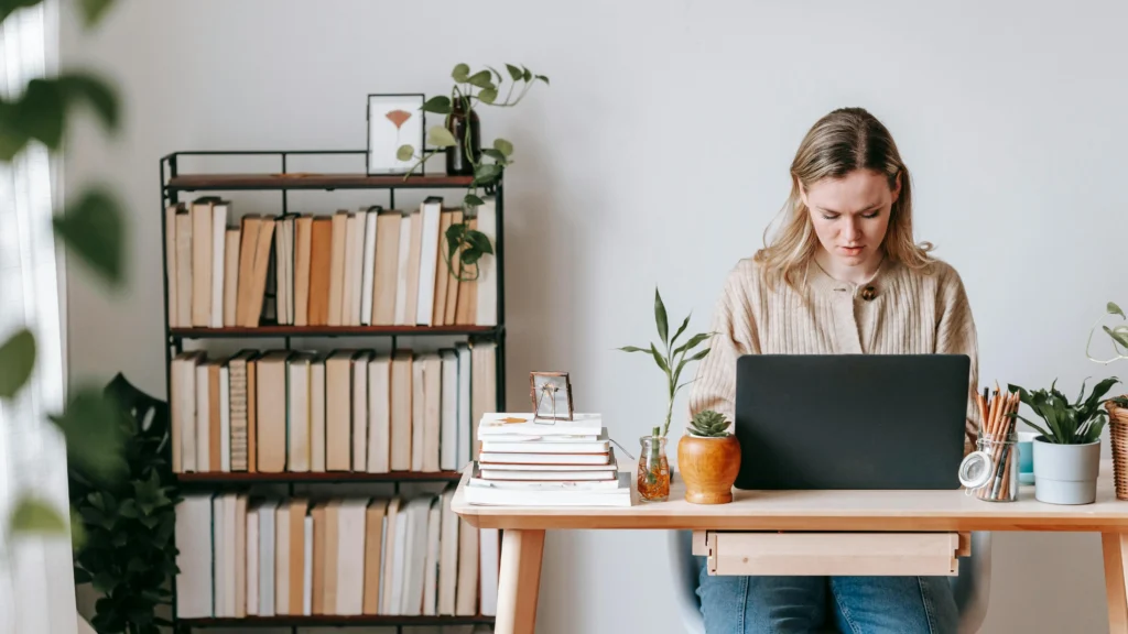 Freelancer using productivity timer while working on laptop at home desk