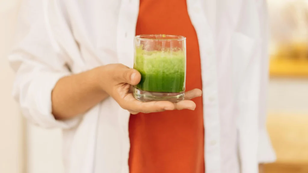 Person holding a glass of smoothie made with whey protein concentrate