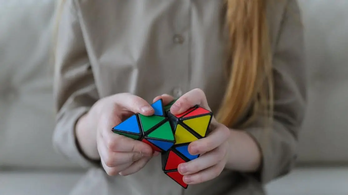 Girl solving colorful triangle puzzle, step 5 of 10 ways to improve memory