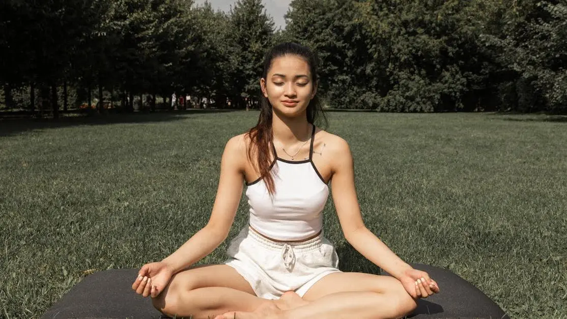 Woman practicing lotus pose outdoors, promoting dopamine balance