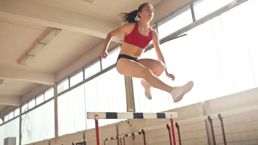 Woman performing high knee jumps during HIIT exercises for women