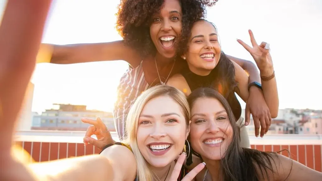 Cheerful women taking a selfie, illustrating how to trigger dopamine in a woman through social bonding.