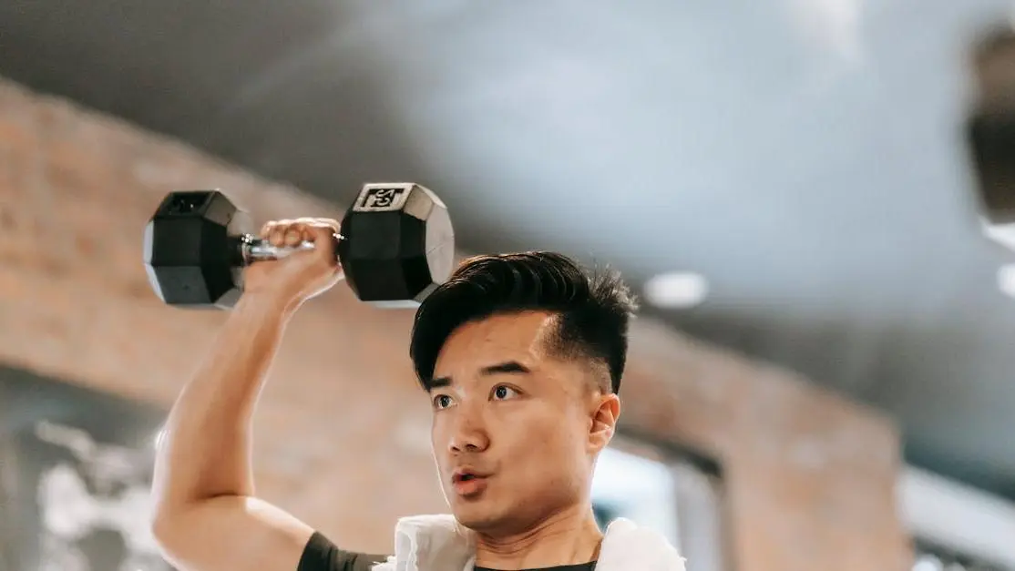 Man performing shoulder impingement syndrome exercises with a dumbbell in gym