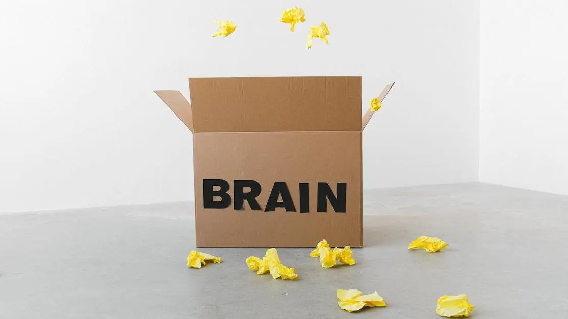 Crumpled yellow paper near a Brain-labeled box on a white background